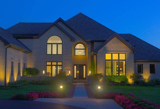 Large home with landscape lighting company Winnetka - lighting by American National.