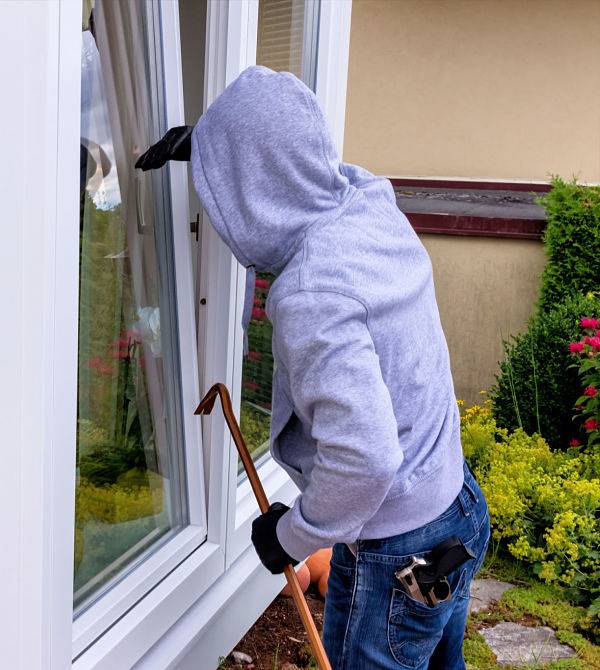 American National Sprinkler & Lighting - Glencoe Landscape Lighting can help deter burglars - a burglar trying to break in an open window with a crowbar.