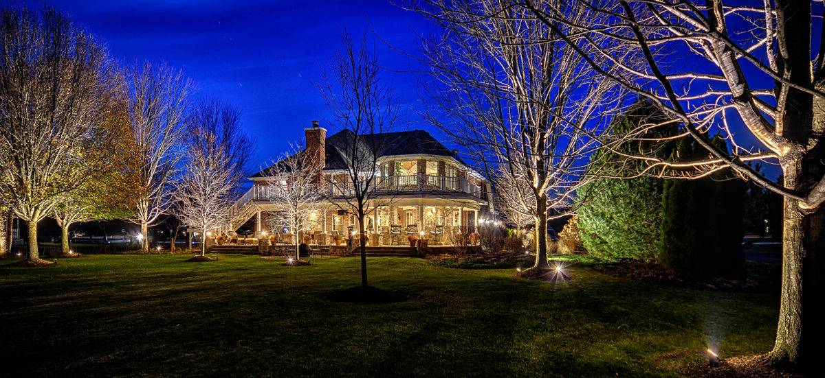 American National Sprinkler & Lighting - landscape lighting system installed in a home in Hawthorn Woods - home at night time.