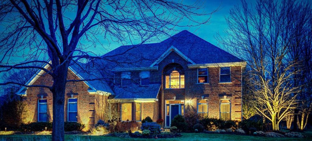 American National Sprinkler & Lighting - a landscape lighting system was installed in a home in Hawthorn Woods - landscape lighting system illuminating home in the evening.